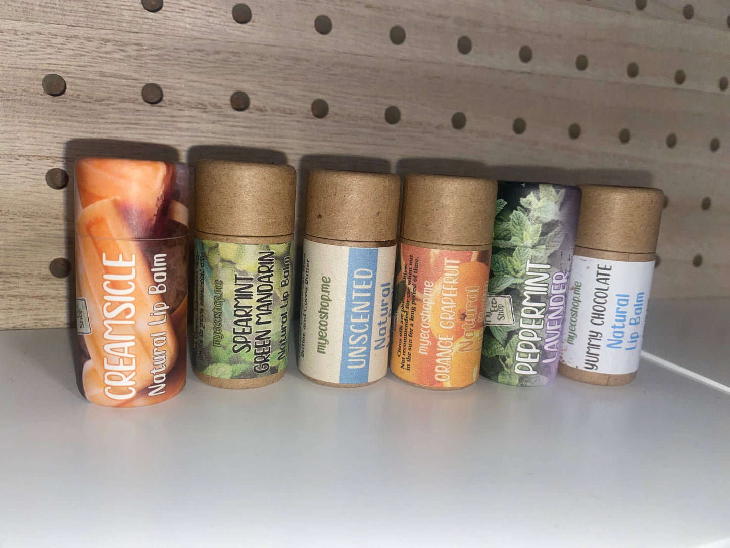 Variety of natural lip balms lined up on a shelf.