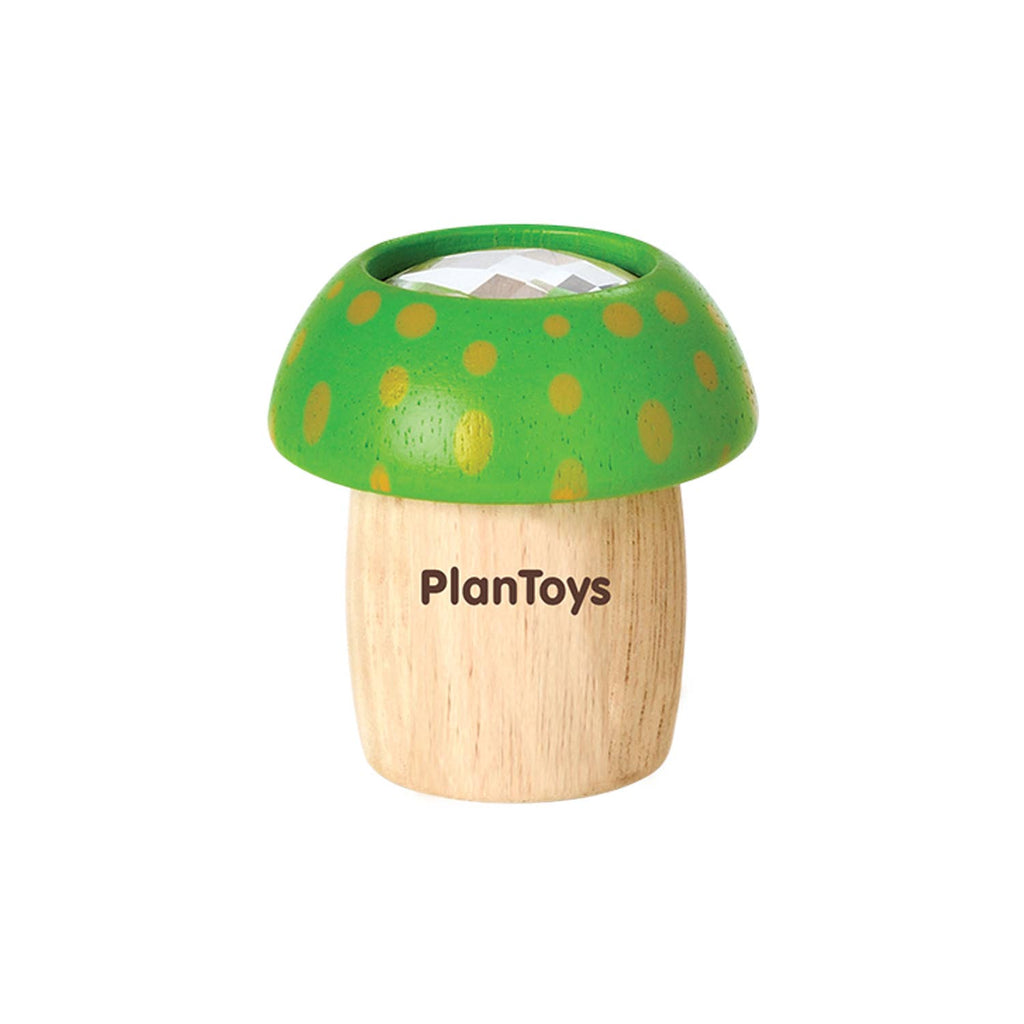 A PlanToys Mushroom Kaleidoscope, a wooden toy shaped like a mushroom with a green cap and yellow spots, features the brand name "plantoys" on its stem. This unique piece includes a kaleidoscope feature to explore.