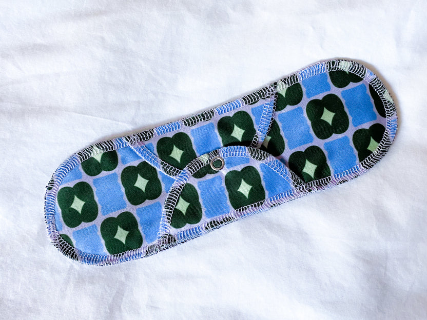 Moderate- Organic Plum Thyme Reusable Menstrual Cloth Period Pad with a blue and green pattern, laid out flat on a white background, featuring enhanced absorbency.
