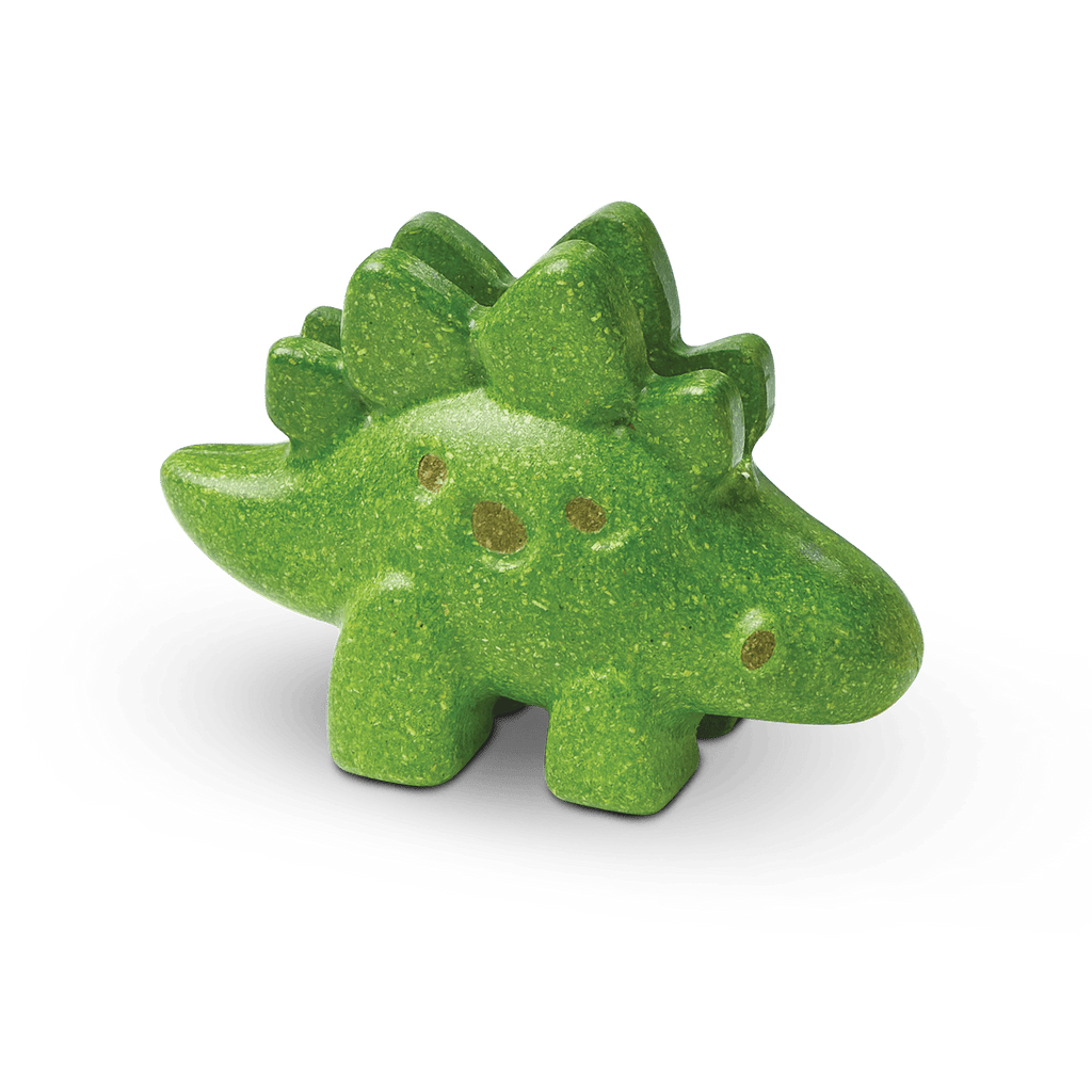 A green, PlanToys - Stegosaurus-shaped bath bomb with glitter on a dark background, perfect for creative playtime.