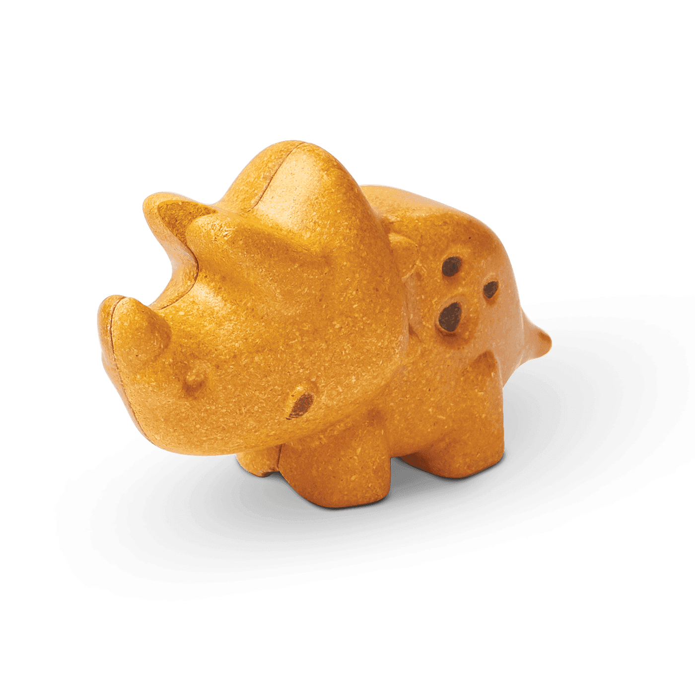 A sustainable PlanToys Triceratops shaped like a cookie on a green background with its shadow visible.