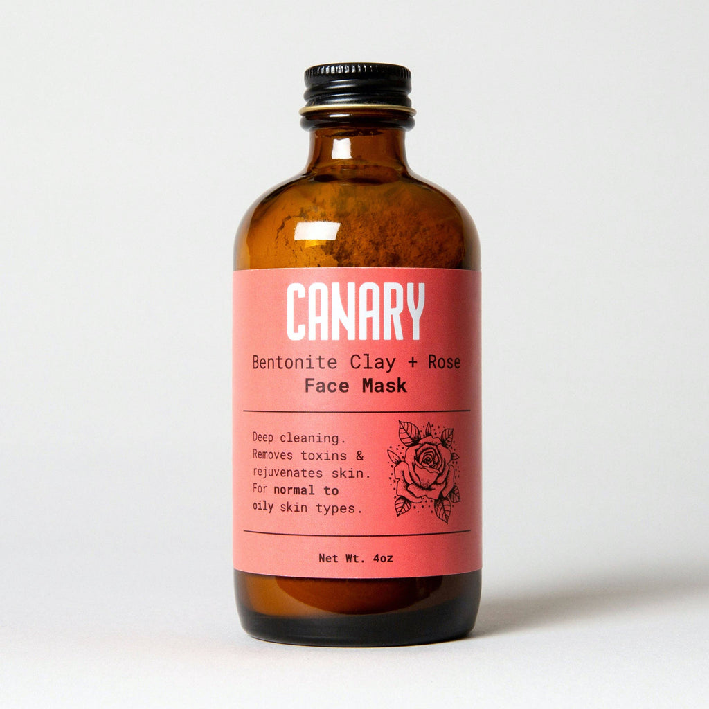 Amber glass bottle with a pink label for Canary Clean Products - Bentonite Clay + Rose Face Mask, indicating it removes toxins and rejuvenates skin for normal to oily skin types. This vegan and cruelty.